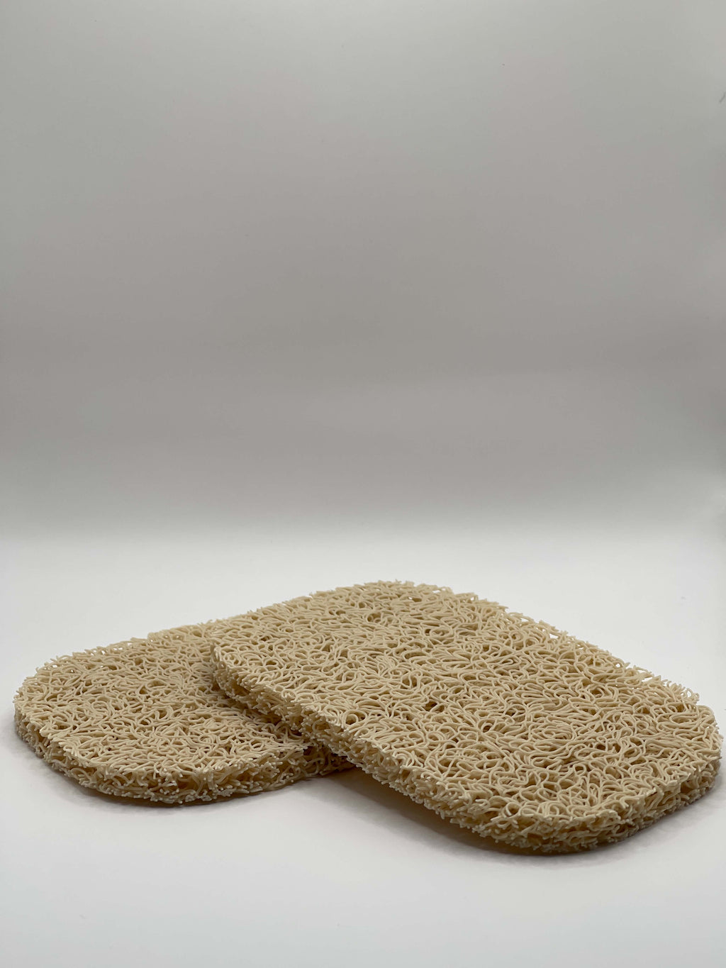 Two rectangular, beige soap holders on a white background