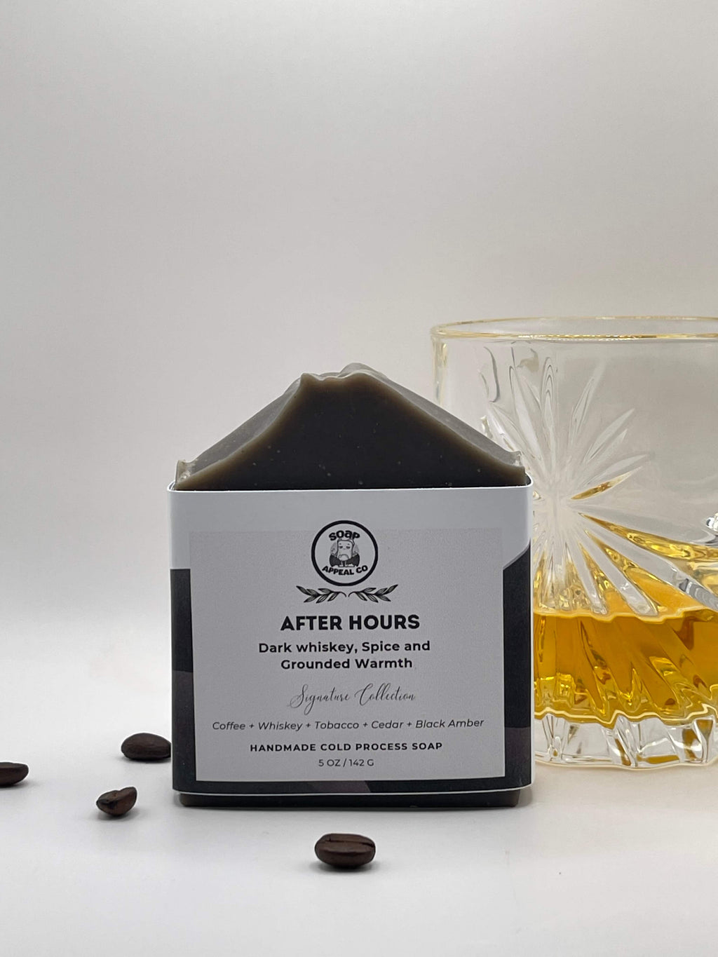 Soap bar labeled 'After Hours' with a glass of whiskey and coffee beans on a white background