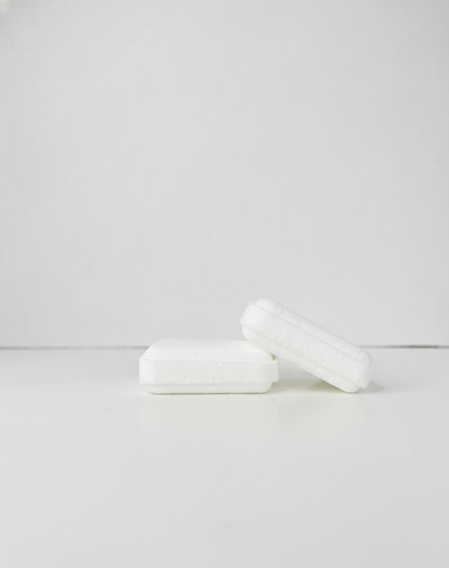 Two white square shower steamers on a light gray background