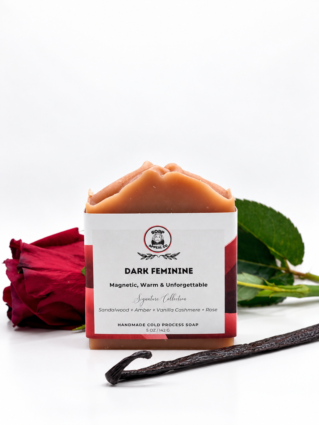 red soap with white and red label on white background with red rose and vanilla bean