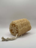 Natural Loofah sponge with a tie on a light gray background