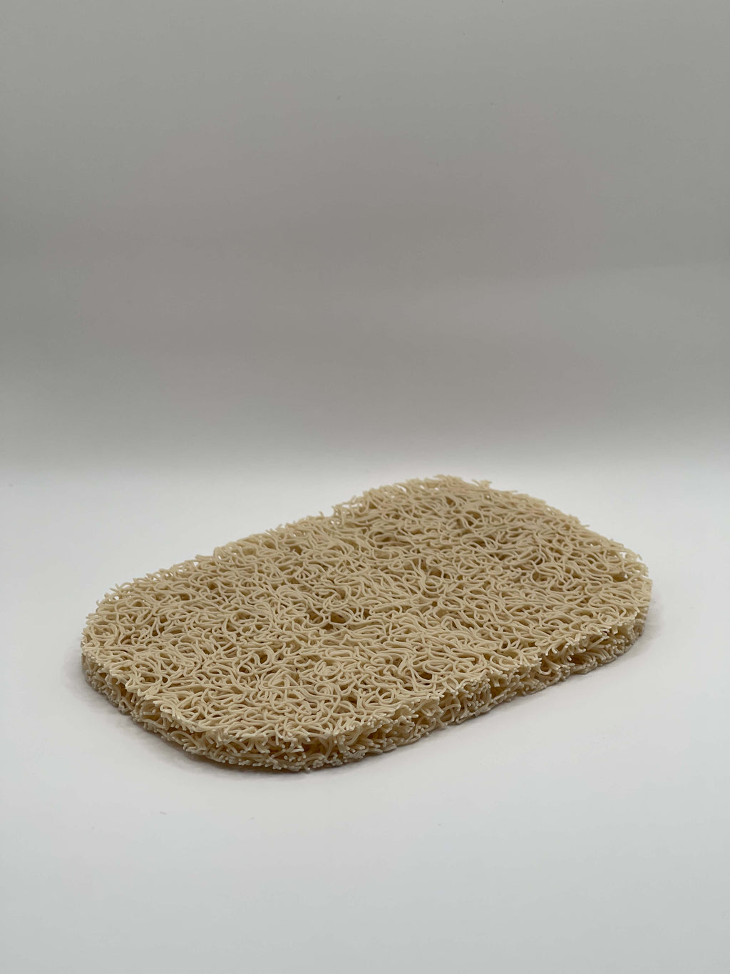 Beige loofah pad on a white background