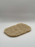 Beige loofah pad on a white background